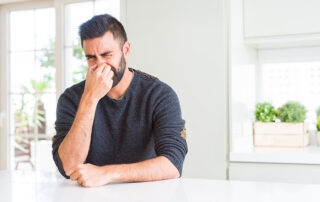 man sitting at the counter pinching his nose