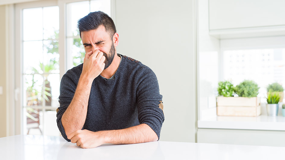 man sitting at the counter pinching his nose