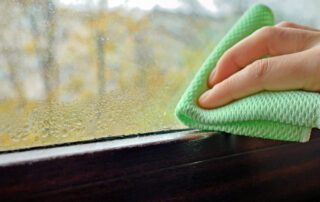 hand wiping condensation off a window