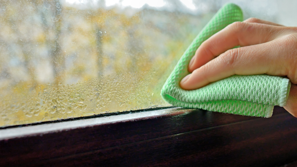 hand wiping condensation off a window