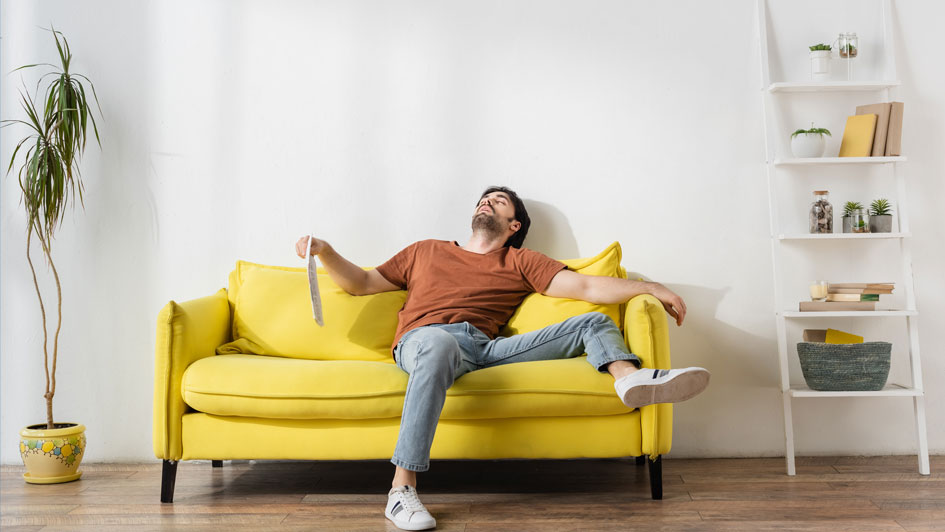 man sweating on his living room couch